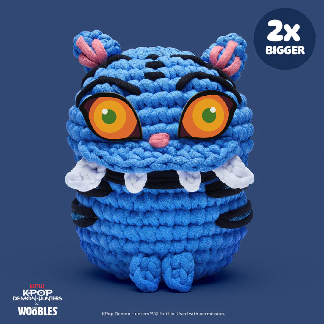 Blue plush toy with large eyes on a dark blue background, featuring Kpop Demon Hunters branding.