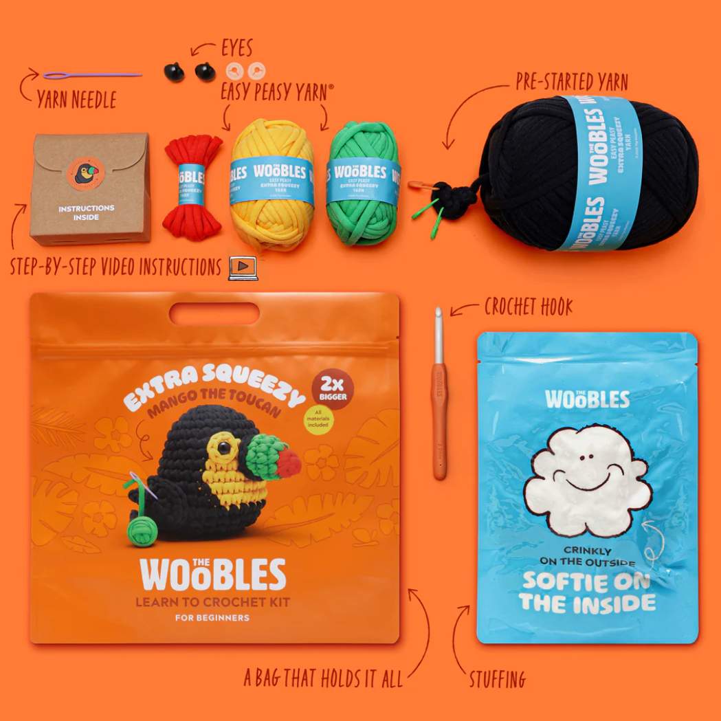 Crochet kit with yarn, hook, and packaging on an orange background