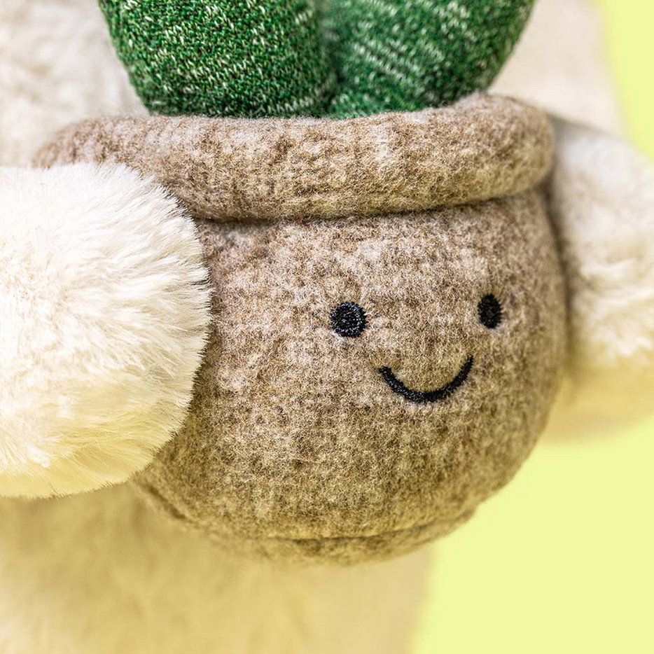 Plush toy with a smiling face and green top on a yellow background