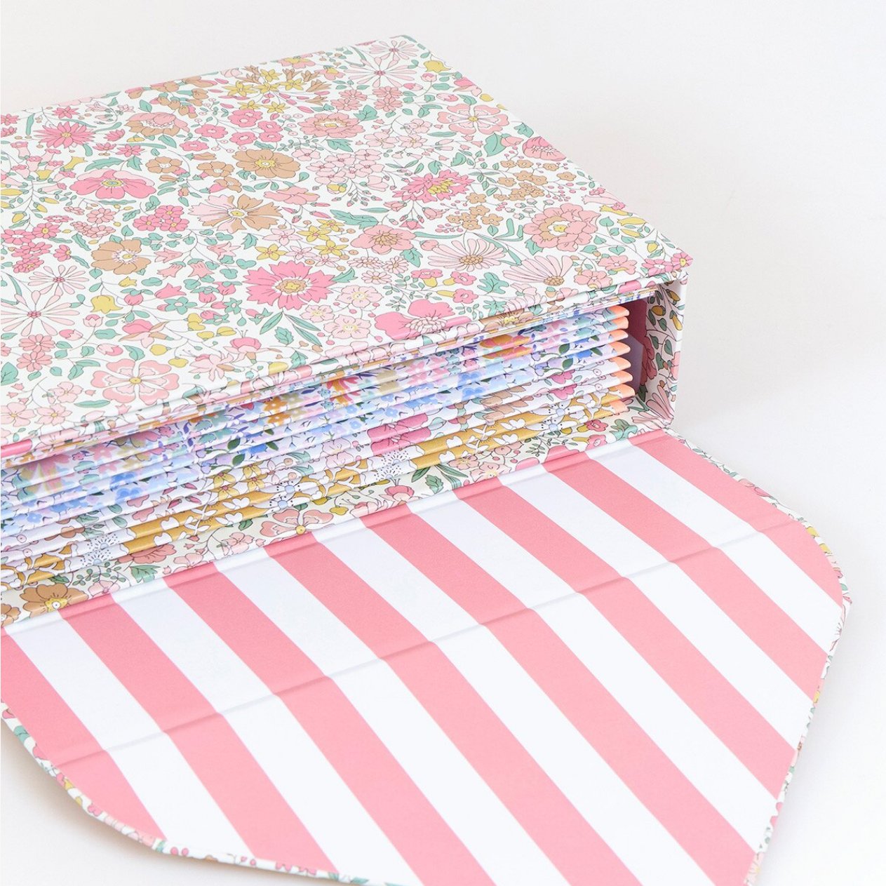 Stack of floral and striped fabric sheets on a white background