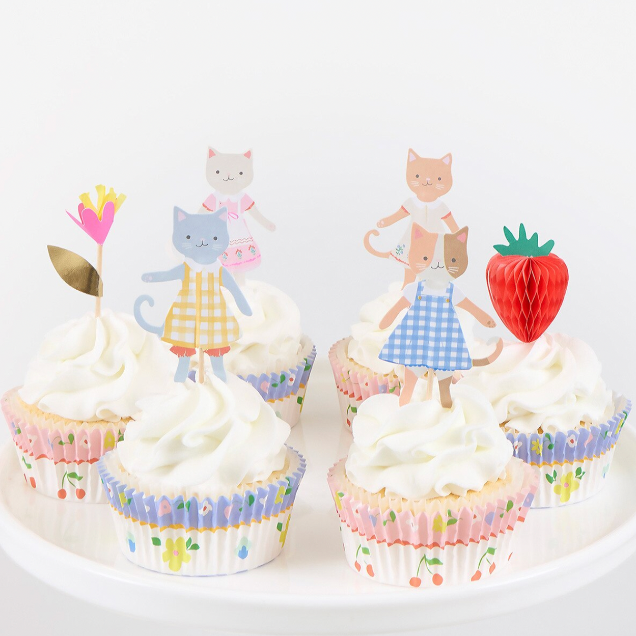 Cupcakes with cat-themed toppers on a white background