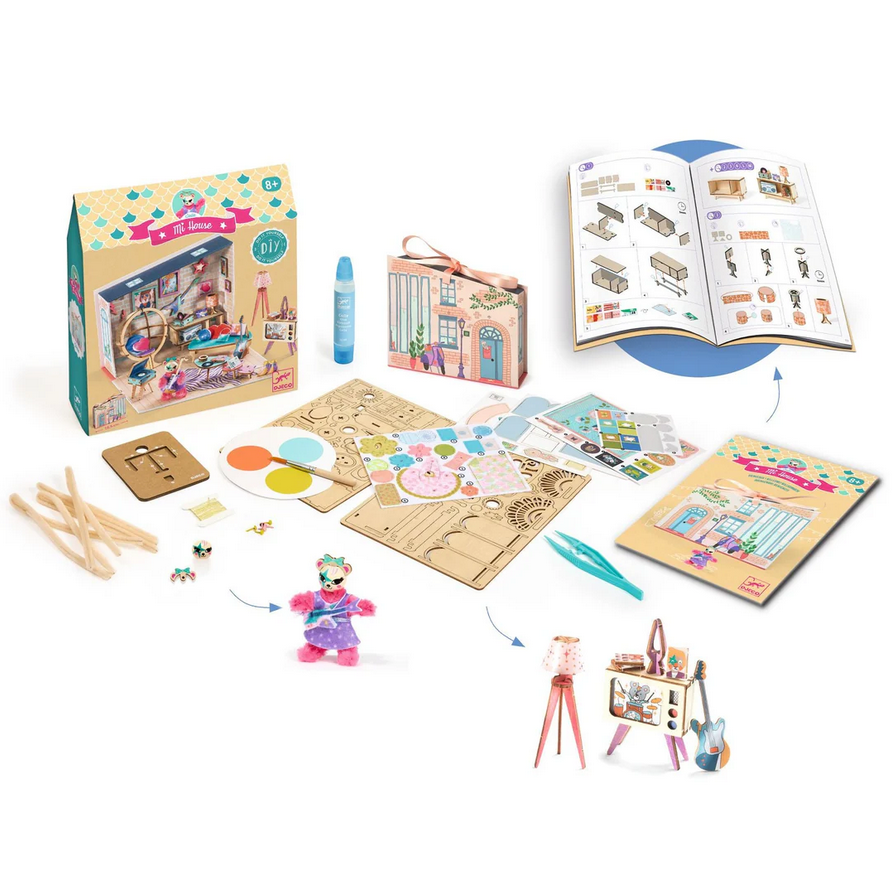 Children's craft kit with wooden pieces, paintbrushes, and a book on a white background