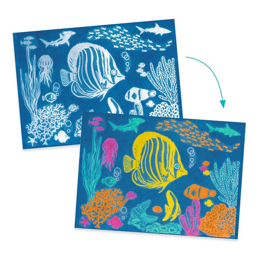 Two sheets of paper with ocean-themed designs, one white and one colorful, on a blue background.