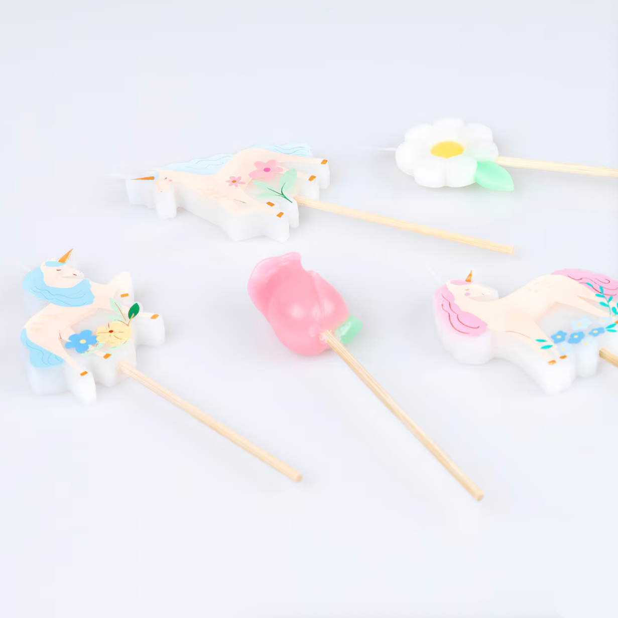 Colorful candles on sticks with decorative elements on a light blue background