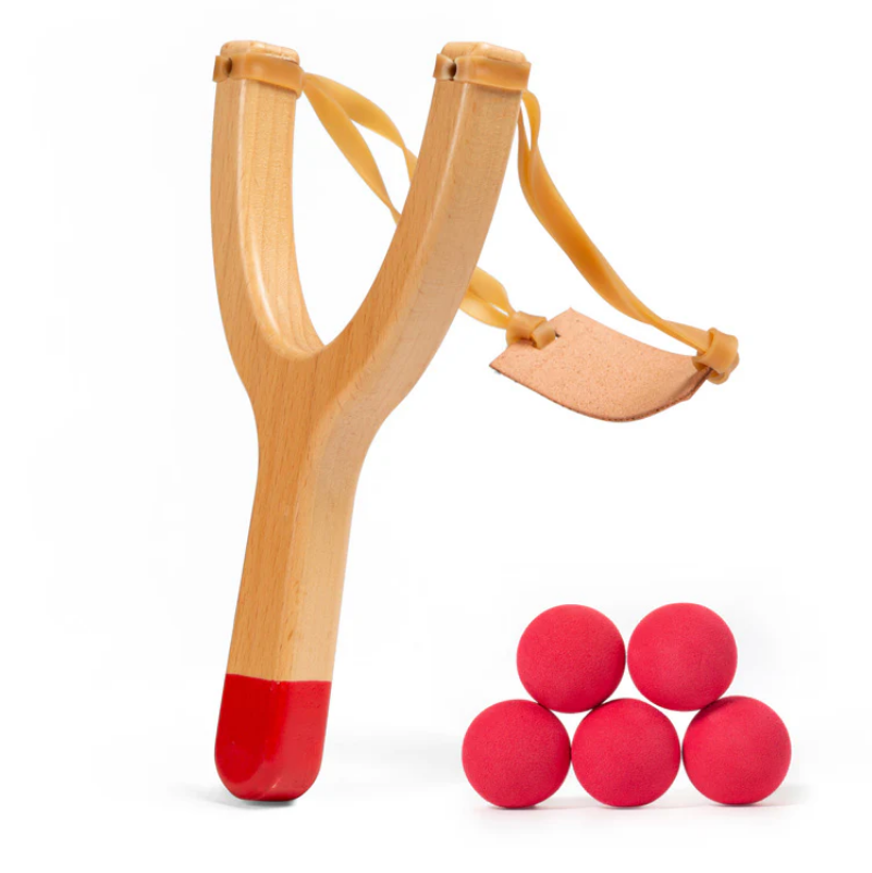 Wooden slingshot with red tips and four red balls on a white background