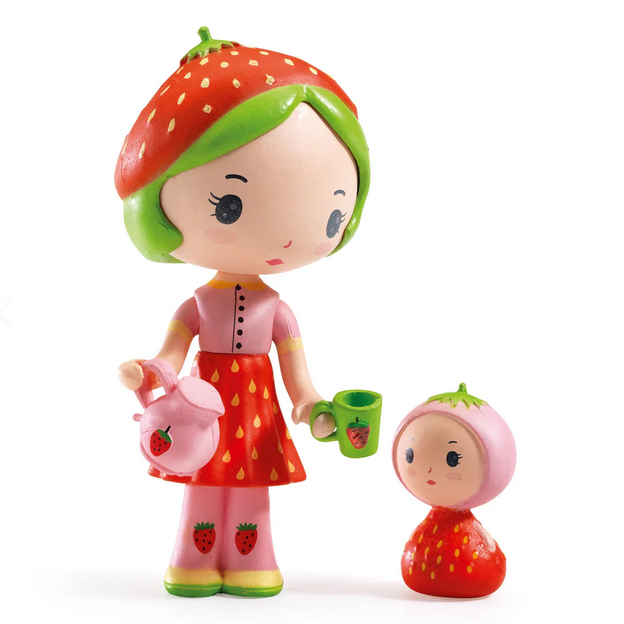 Toy figure of a girl with strawberry-themed outfit and accessories on a white background
