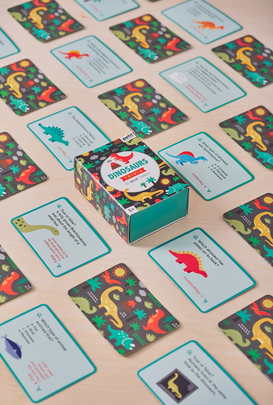 Card game with dinosaur-themed cards and a box on a beige surface