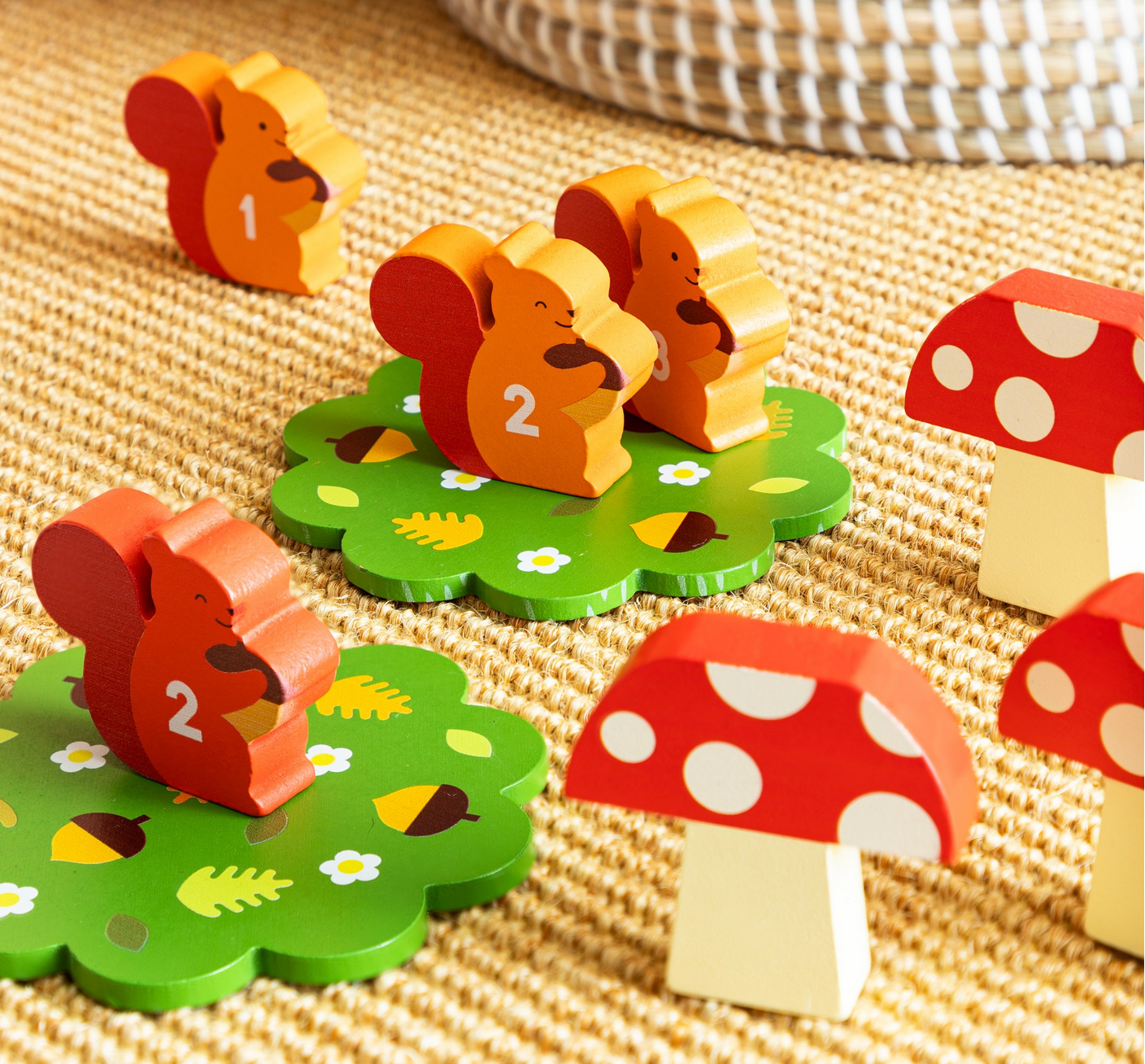 Wooden toys shaped like mice and mushrooms on a textured surface