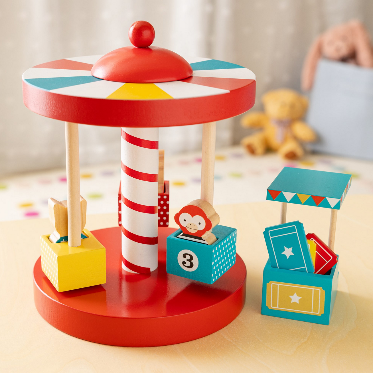 Colorful wooden toy carousel with various elements on a light surface.