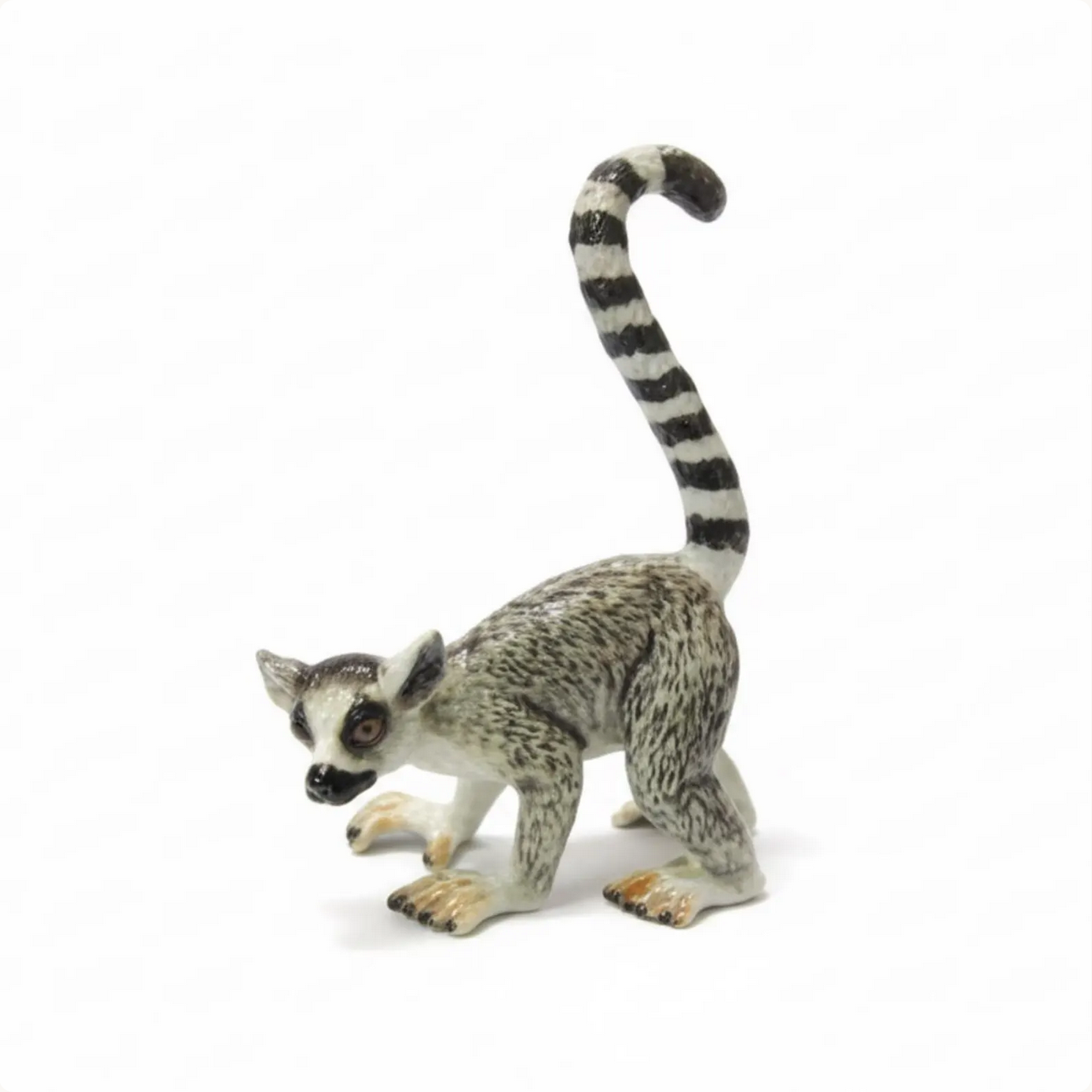 Ring-tailed lemur figurine on a white background