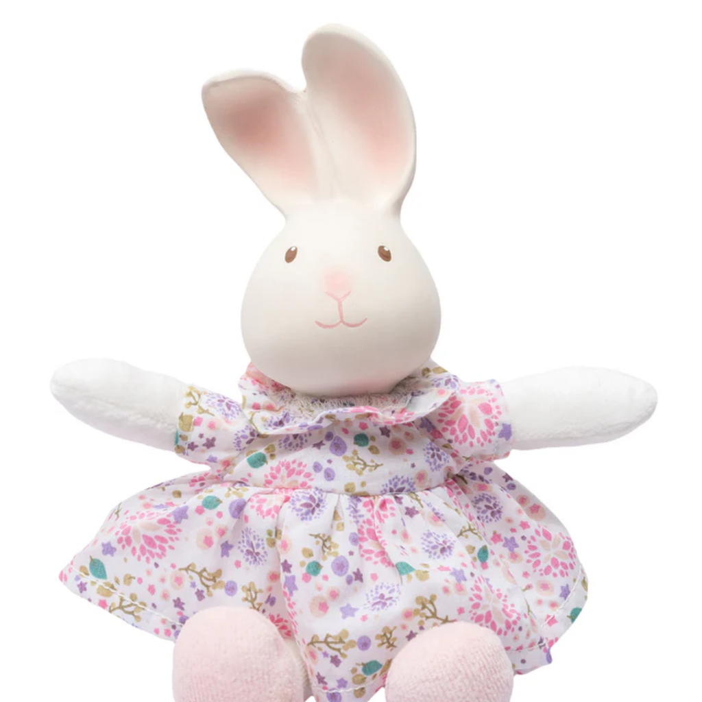 Plush rabbit toy in a floral dress with small illustrations on a white background