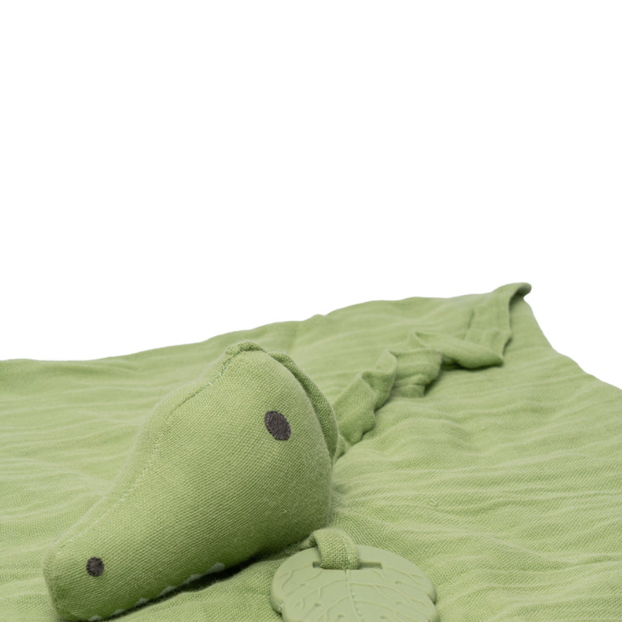 Green crocodile-shaped soft toy on a white background