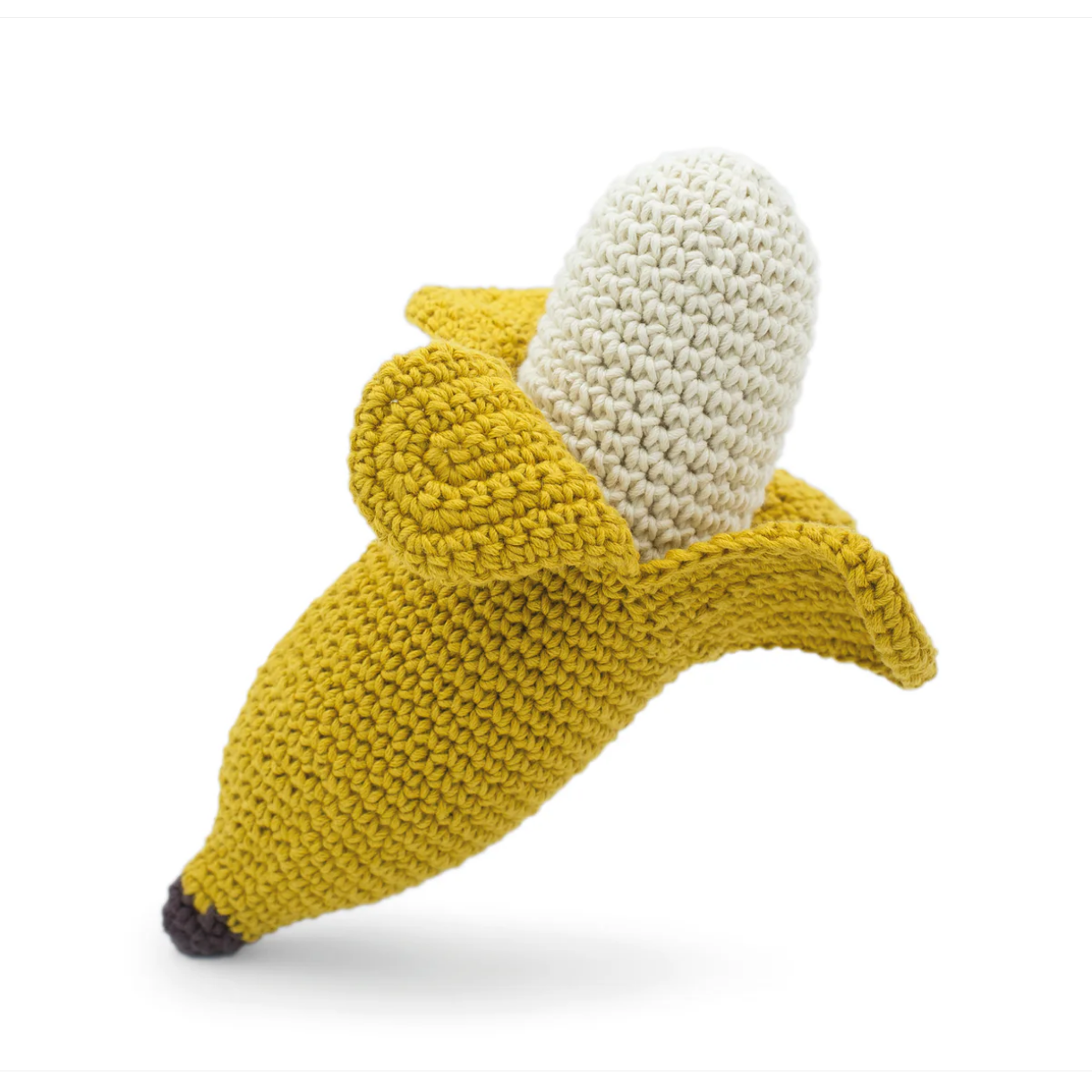 Knitted toy shaped like a banana with a white top on a white background