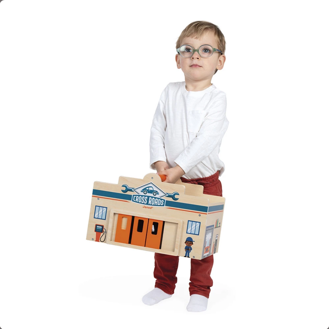 Child holding a toy box with a garage design on a white background