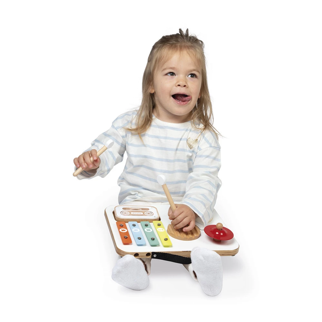 Child playing with a wooden toy piano on a white background