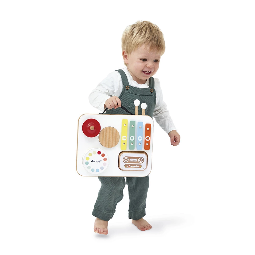 Child holding a colorful toy radio with buttons and knobs on a white background