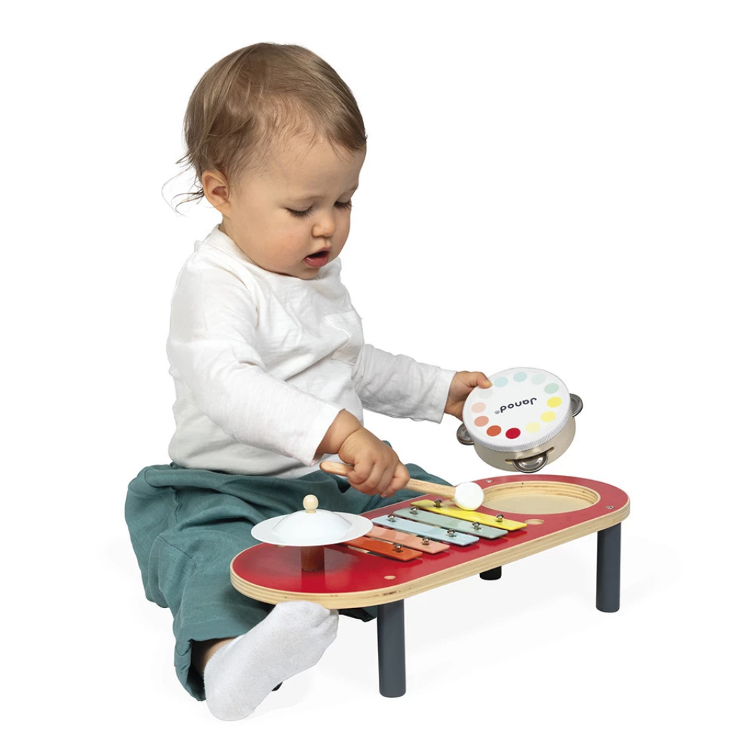 Child playing with a colorful toy music table on a white background