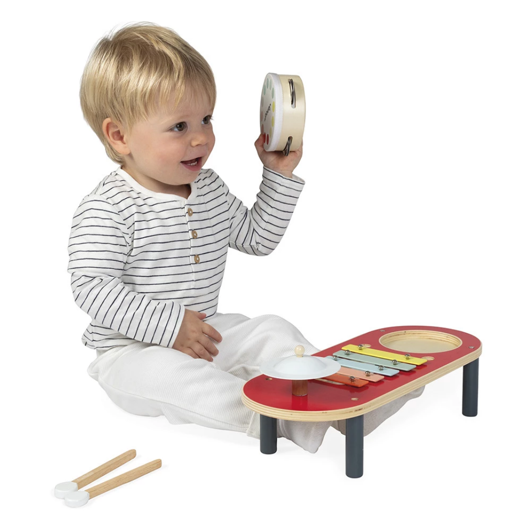 Child playing with a toy music set on a white background