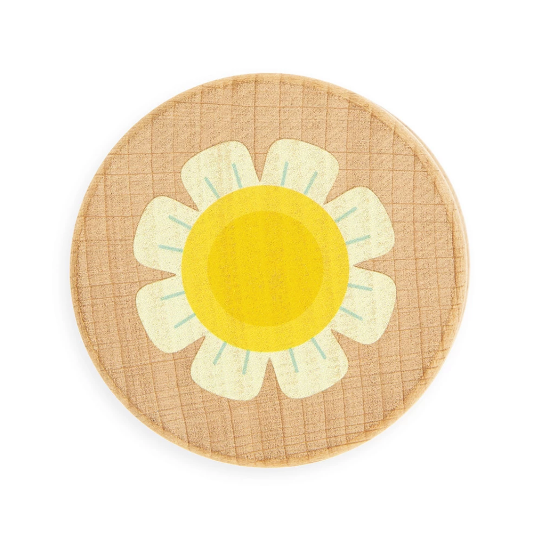 Round rattle with a yellow center and white petals on a plain background