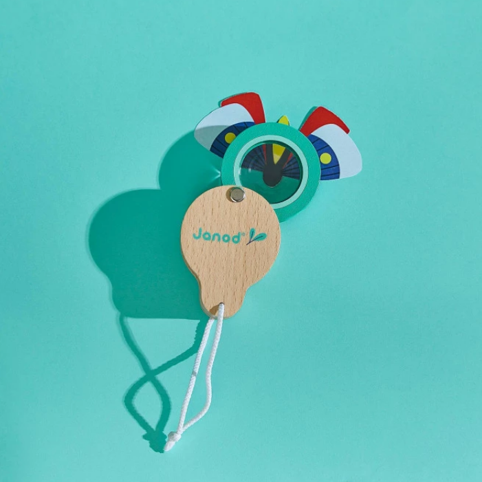 Magnifier with toy butterfly on a teal background