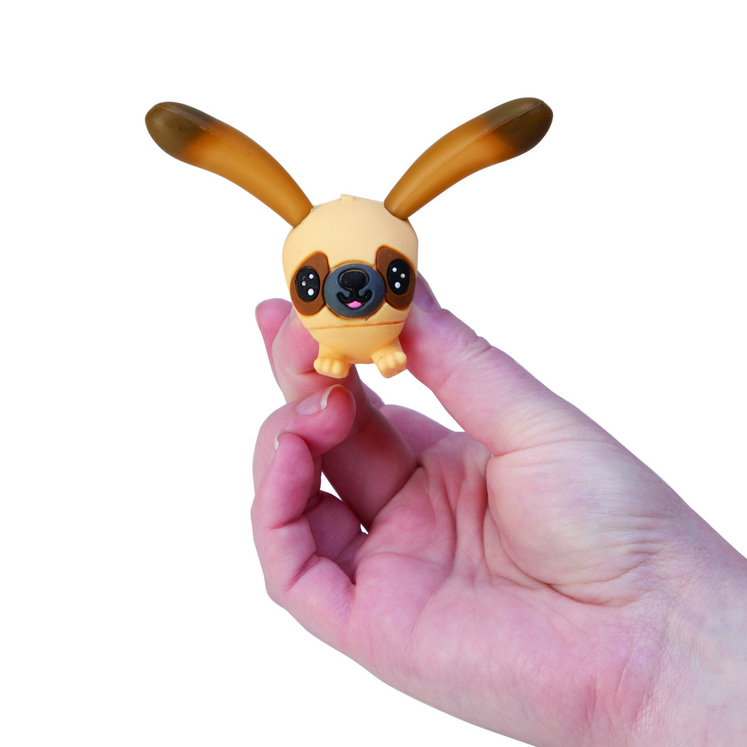 Hand holding a small dog-shaped toy