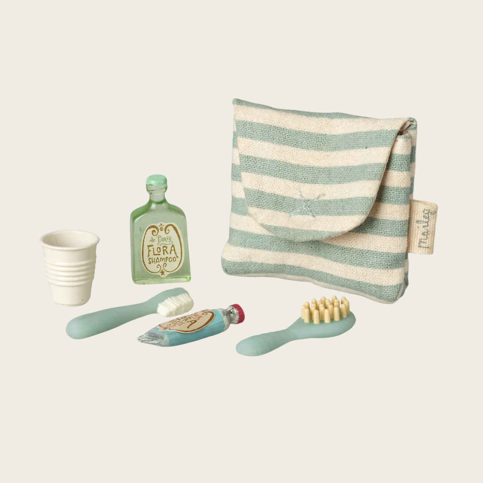 Product display with striped pouch, bottle, cup, and brush on a white background