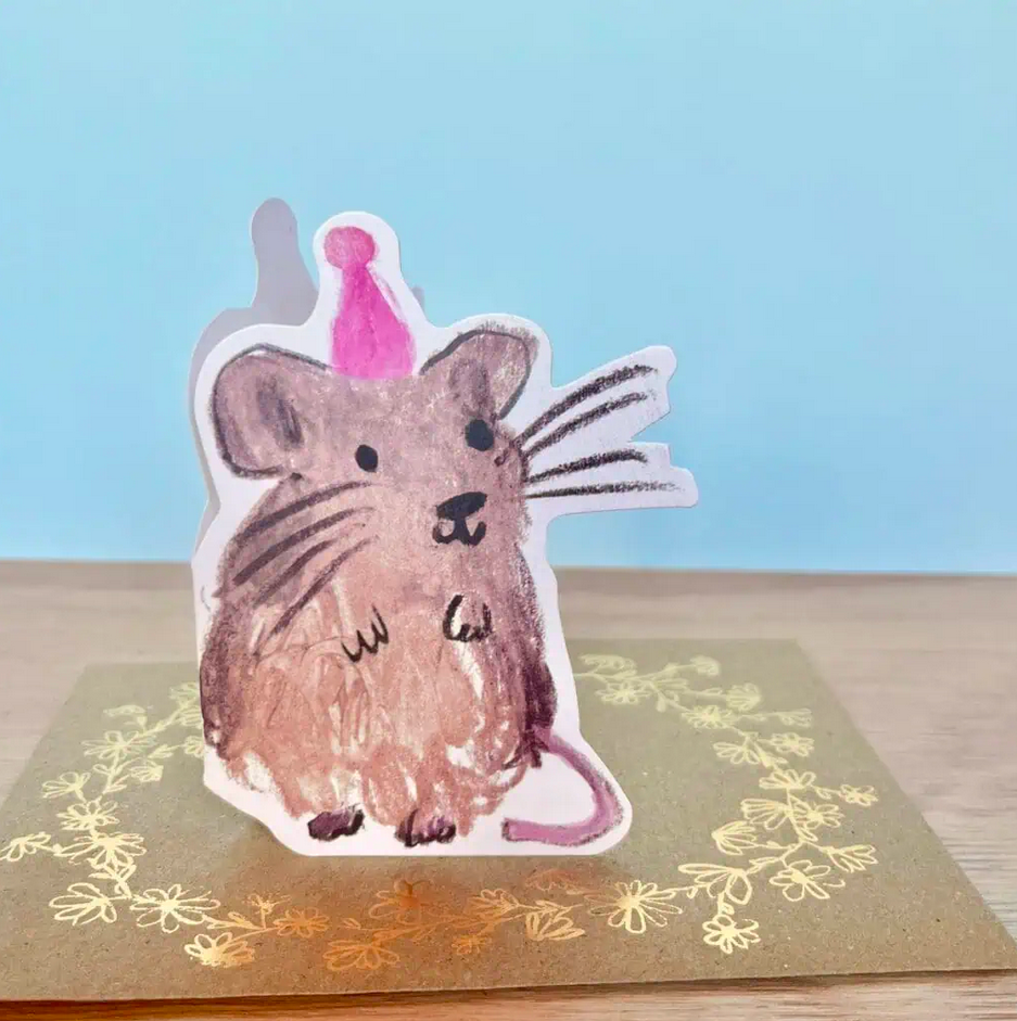 Pop-up card with a mouse illustration wearing a party hat on a floral background
