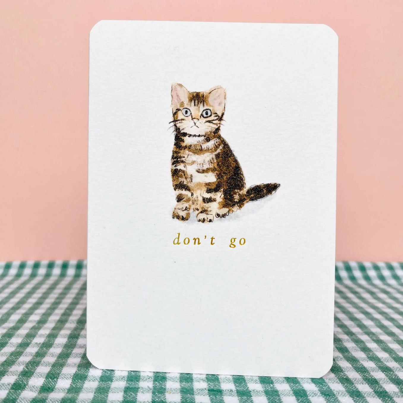 Card with a kitten illustration and 'don't go' text on a checkered tablecloth.