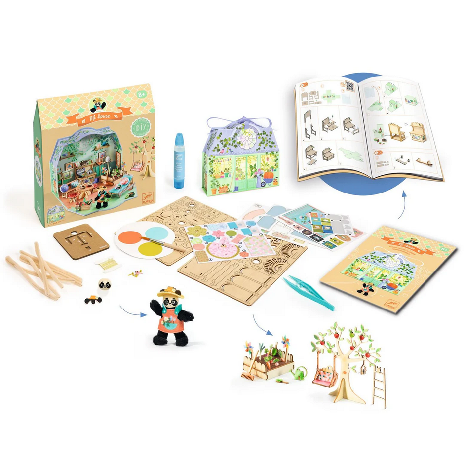 Children's craft kit with wooden pieces, paint, and book on a white background