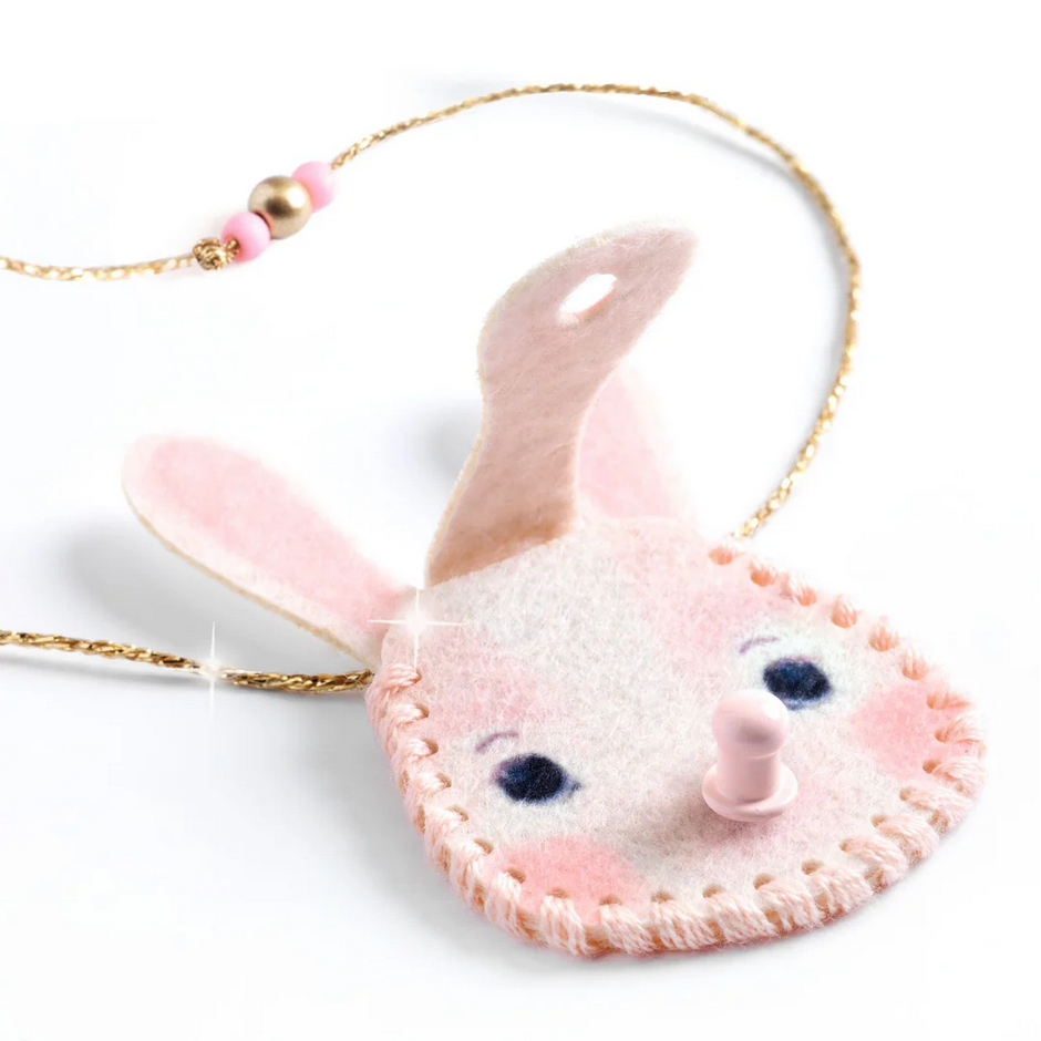 Pink felt bunny keychain with gold chain on a white background