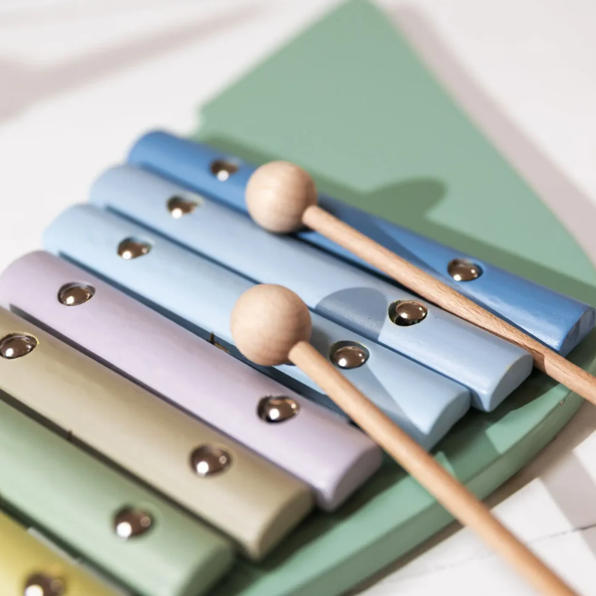Colorful xylophone with wooden mallets on a light background