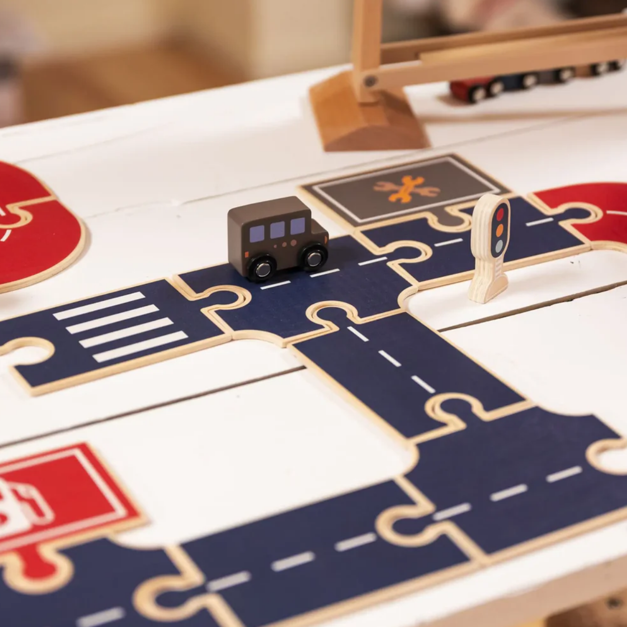 Children's toy train set on a puzzle-like track with traffic lights and signals.