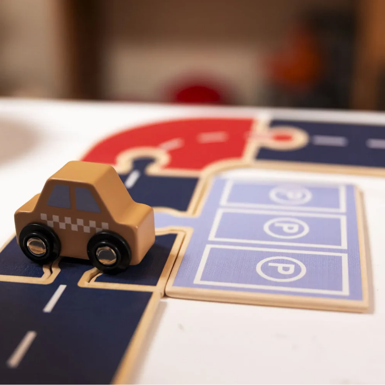 Wooden toy car on a miniature road map with 'EGM' branding.