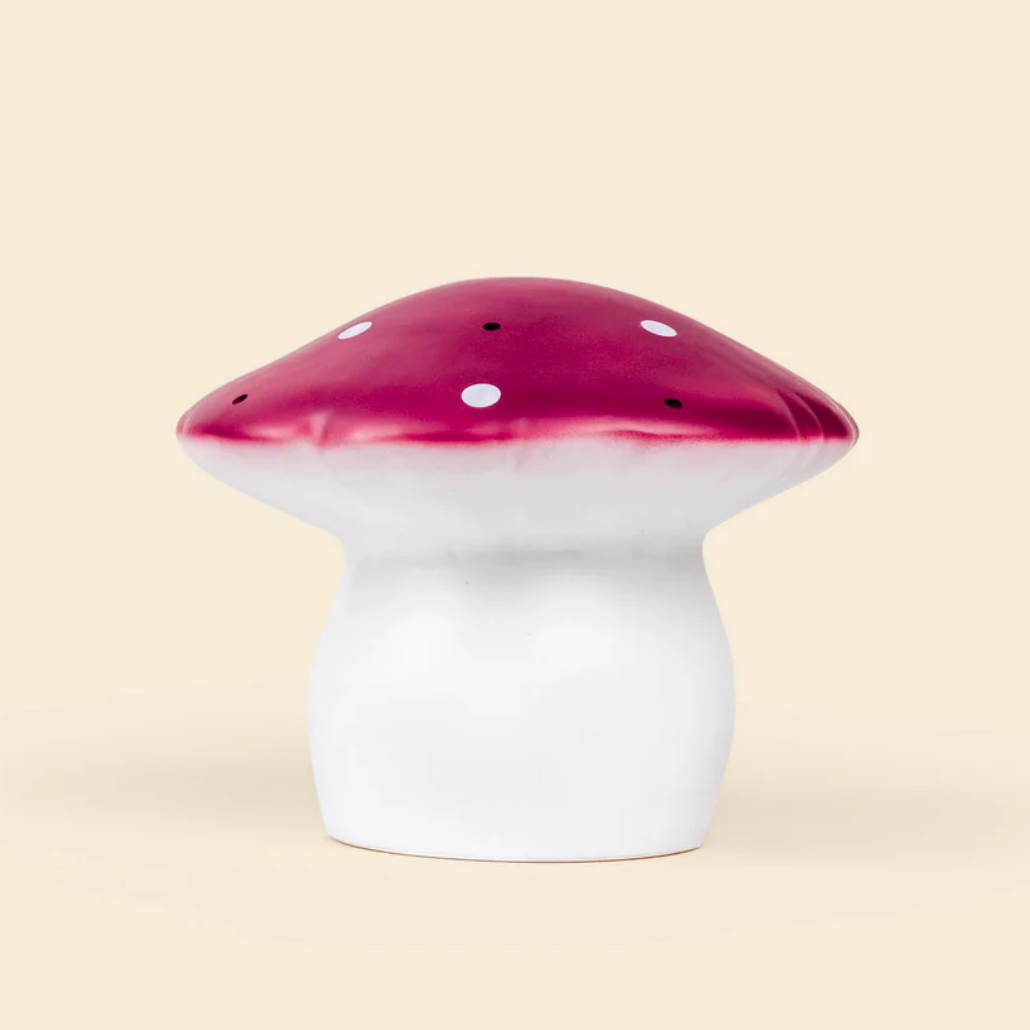 Mushroom-shaped night light with red top and white base on a beige background