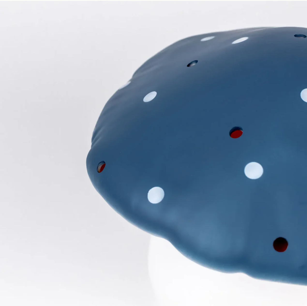 Blue lamp with white spots on a light gray background