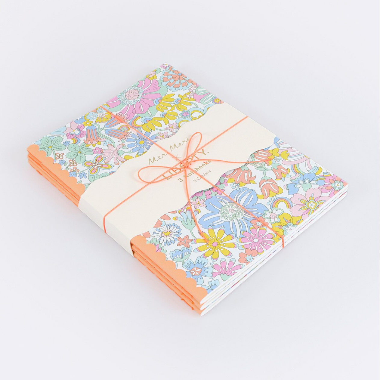 Set of floral-patterned notebooks tied with a ribbon on a light gray background