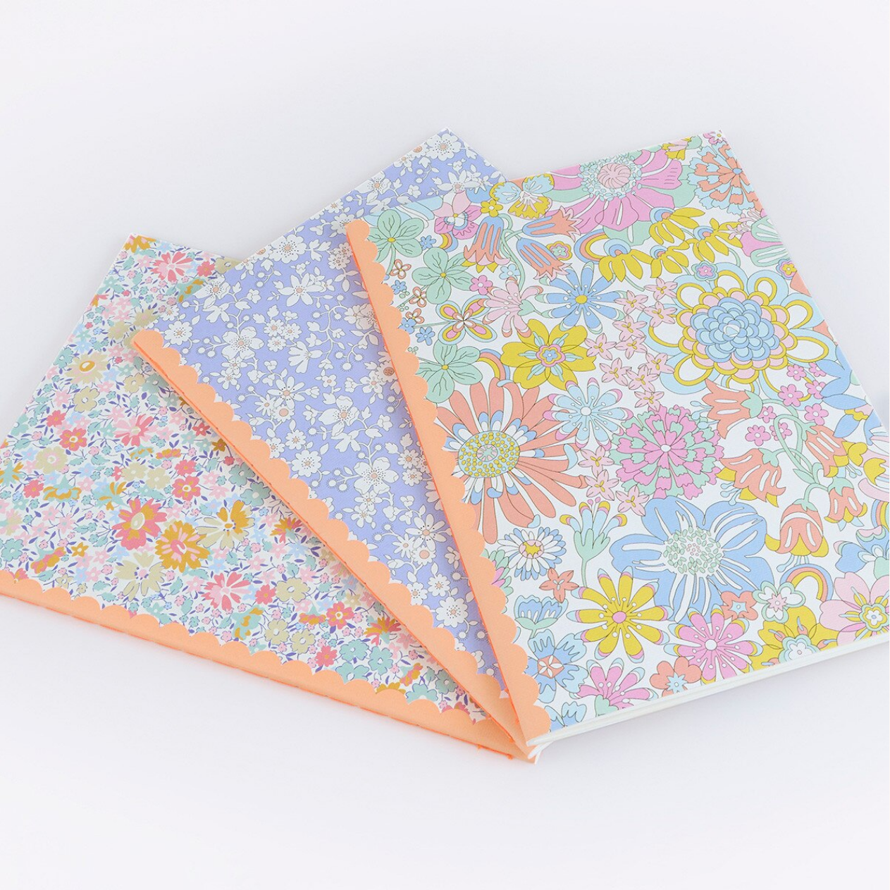 Three sheets of floral-patterned paper in pastel colors on a white background