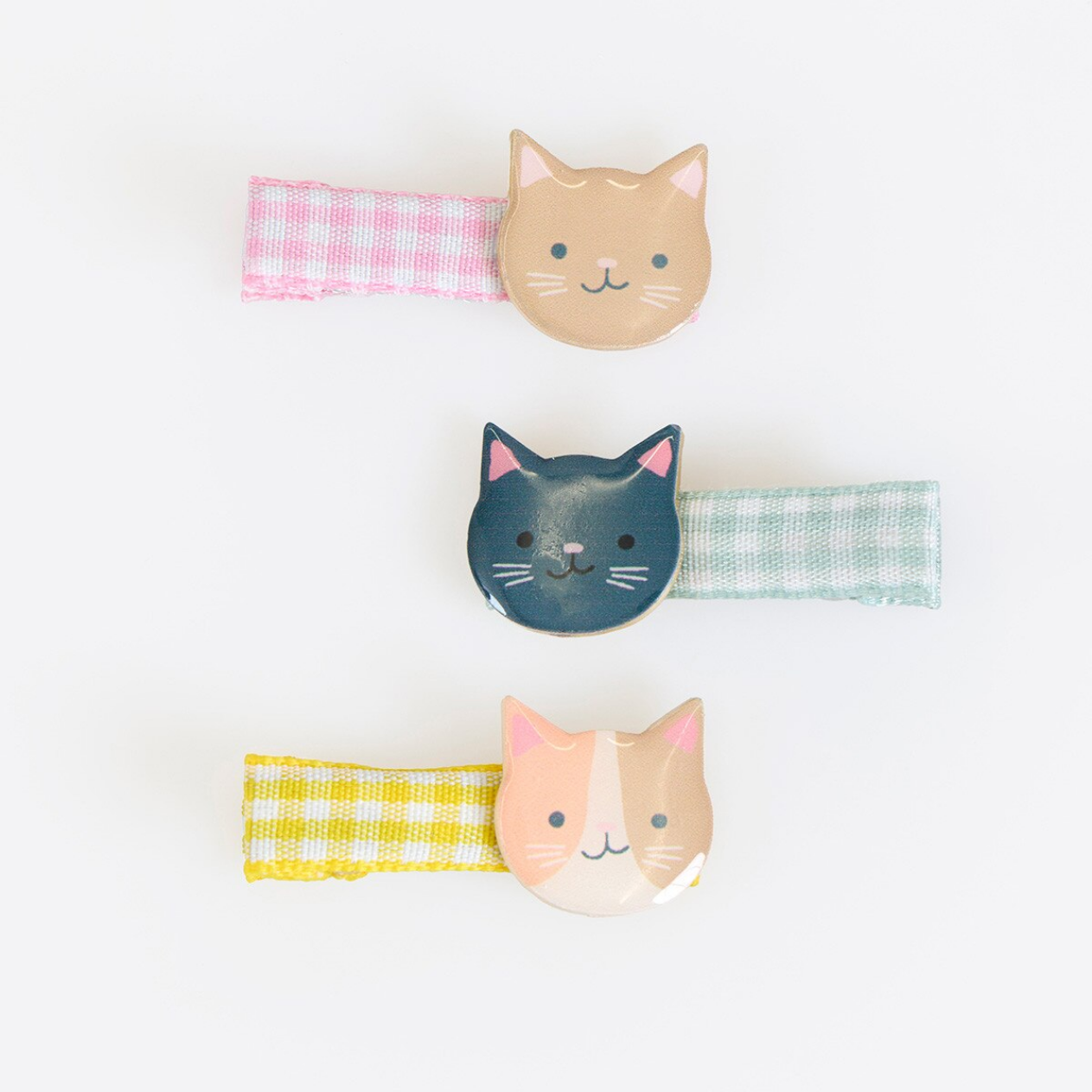 Three cat-shaped hair clips on a white background