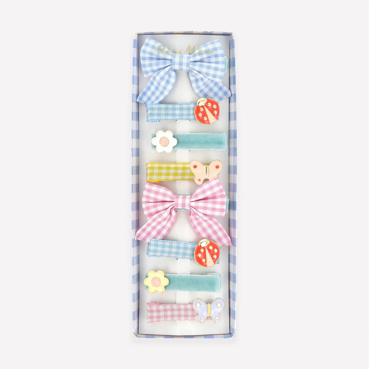 Set of colorful hair accessories including bows and clips in a box on a white background