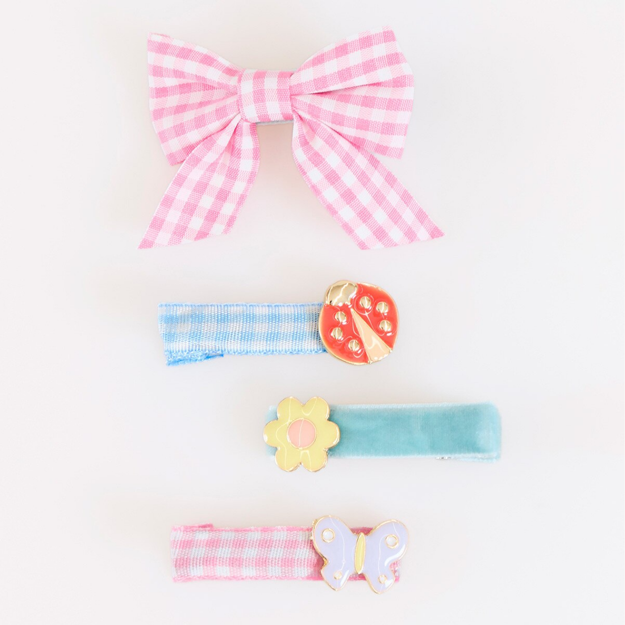 Set of colorful hair accessories including a pink checkered bow, blue striped barrette, and others on a white background.
