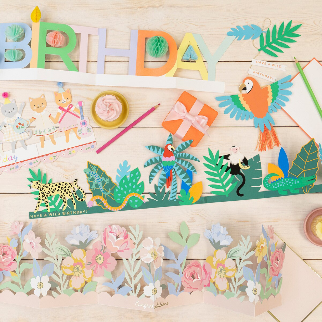 Colorful birthday-themed paper cutouts on a wooden surface
