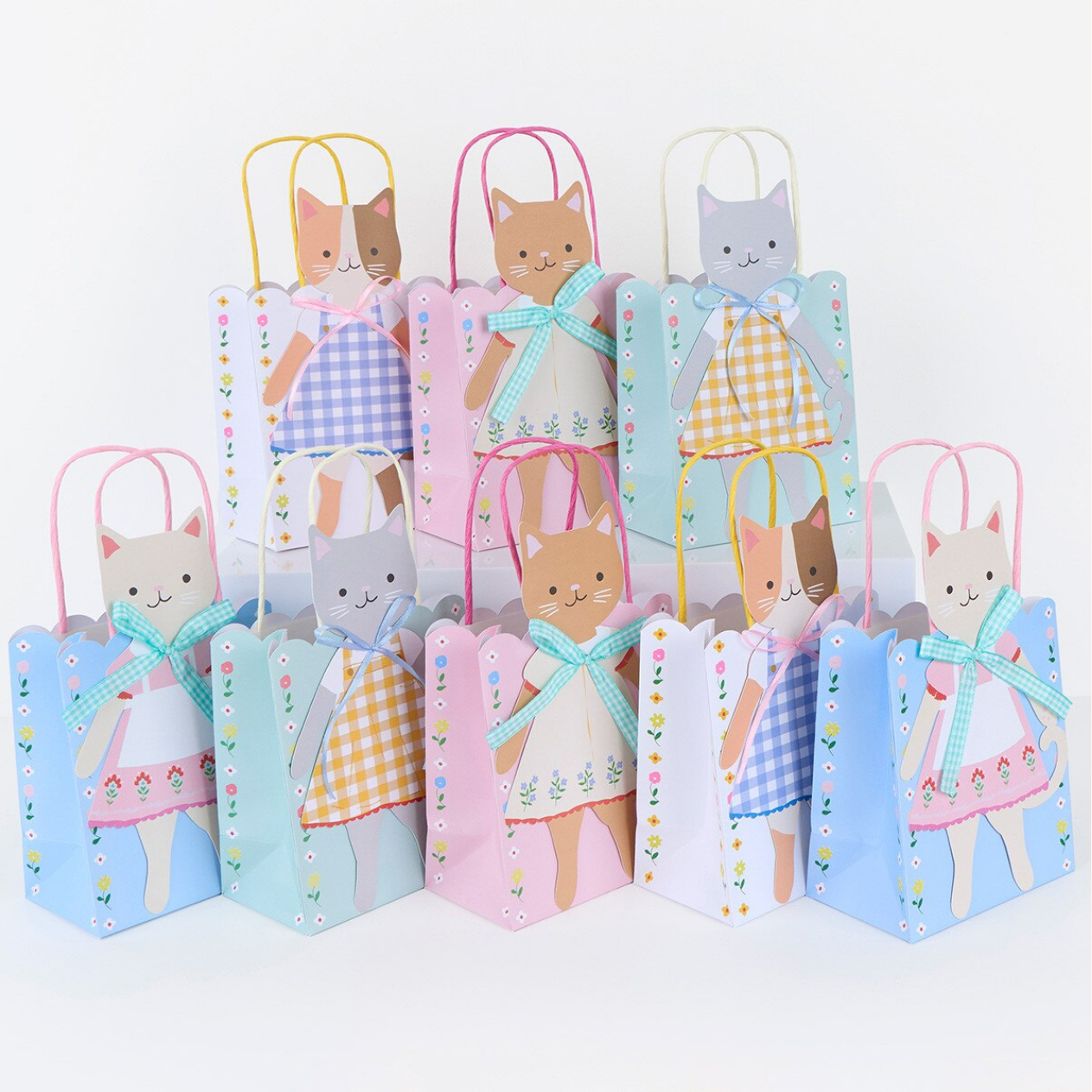 Set of paper bags with cat illustrations and colorful designs on a white background