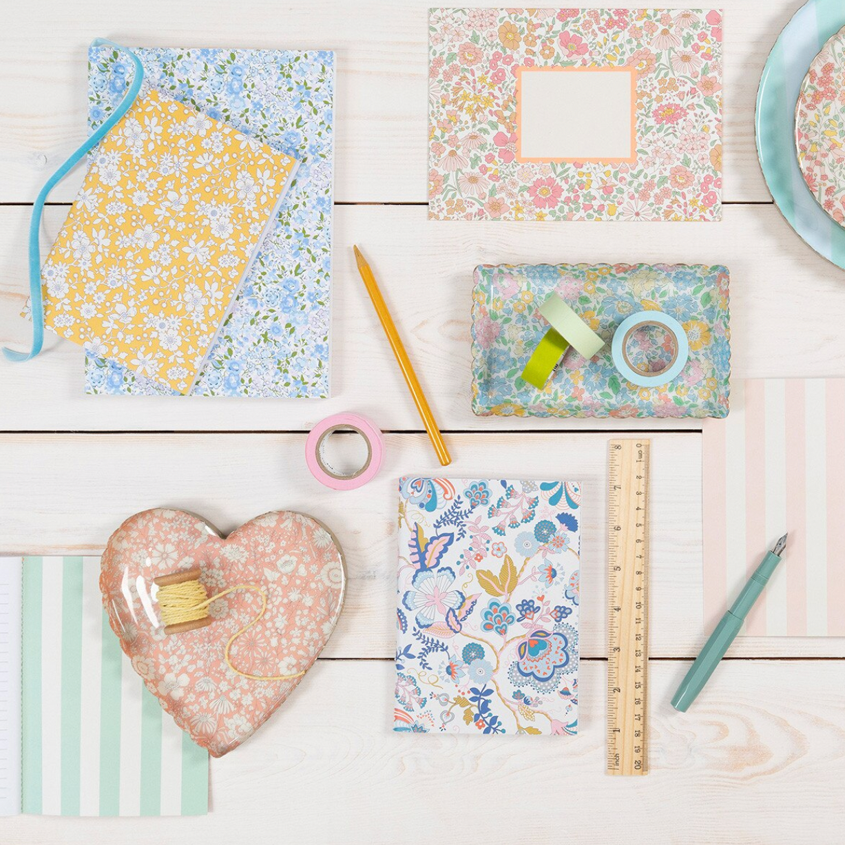 Assorted stationery items with floral patterns on a wooden surface