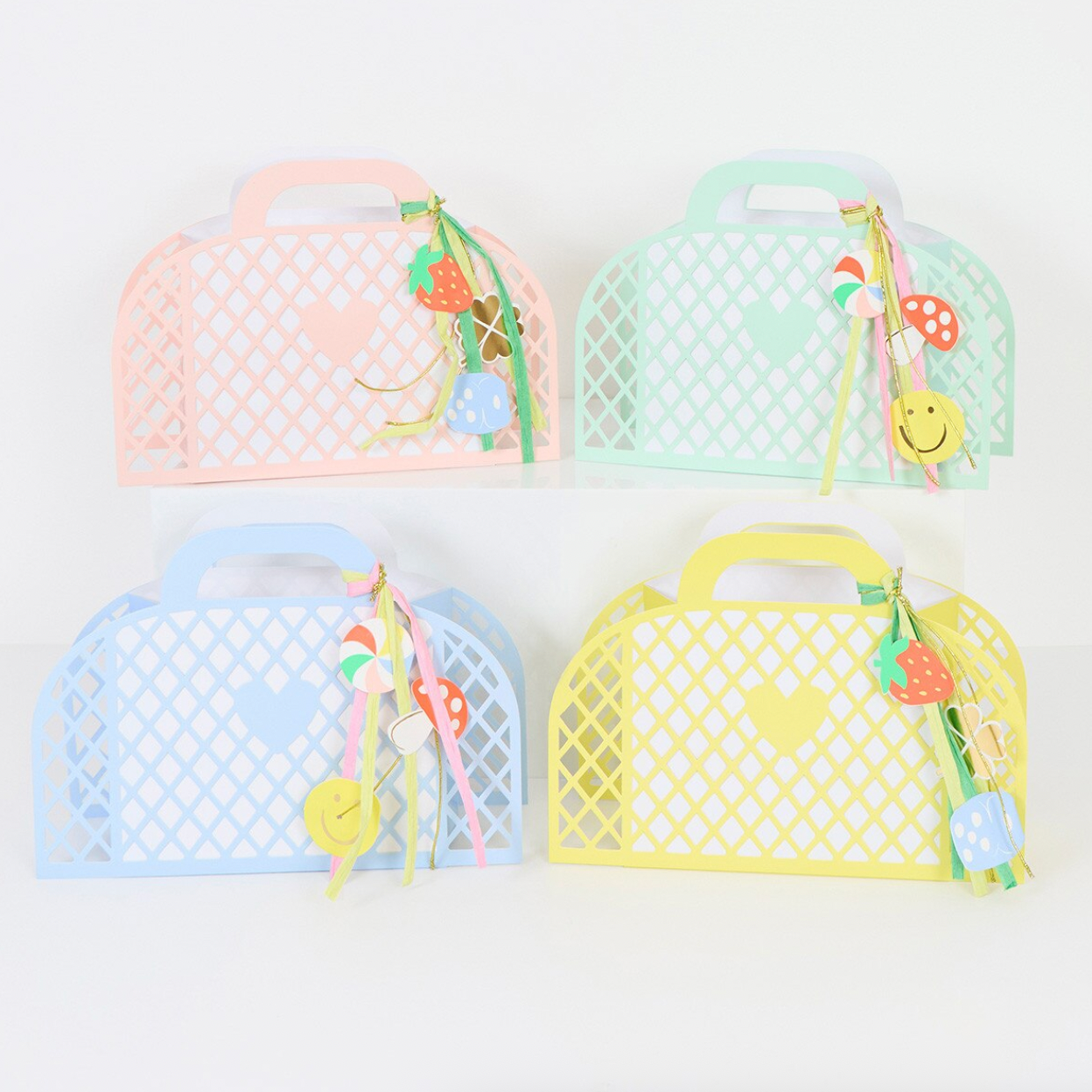 Four colorful mesh bags with decorative handles on a white background