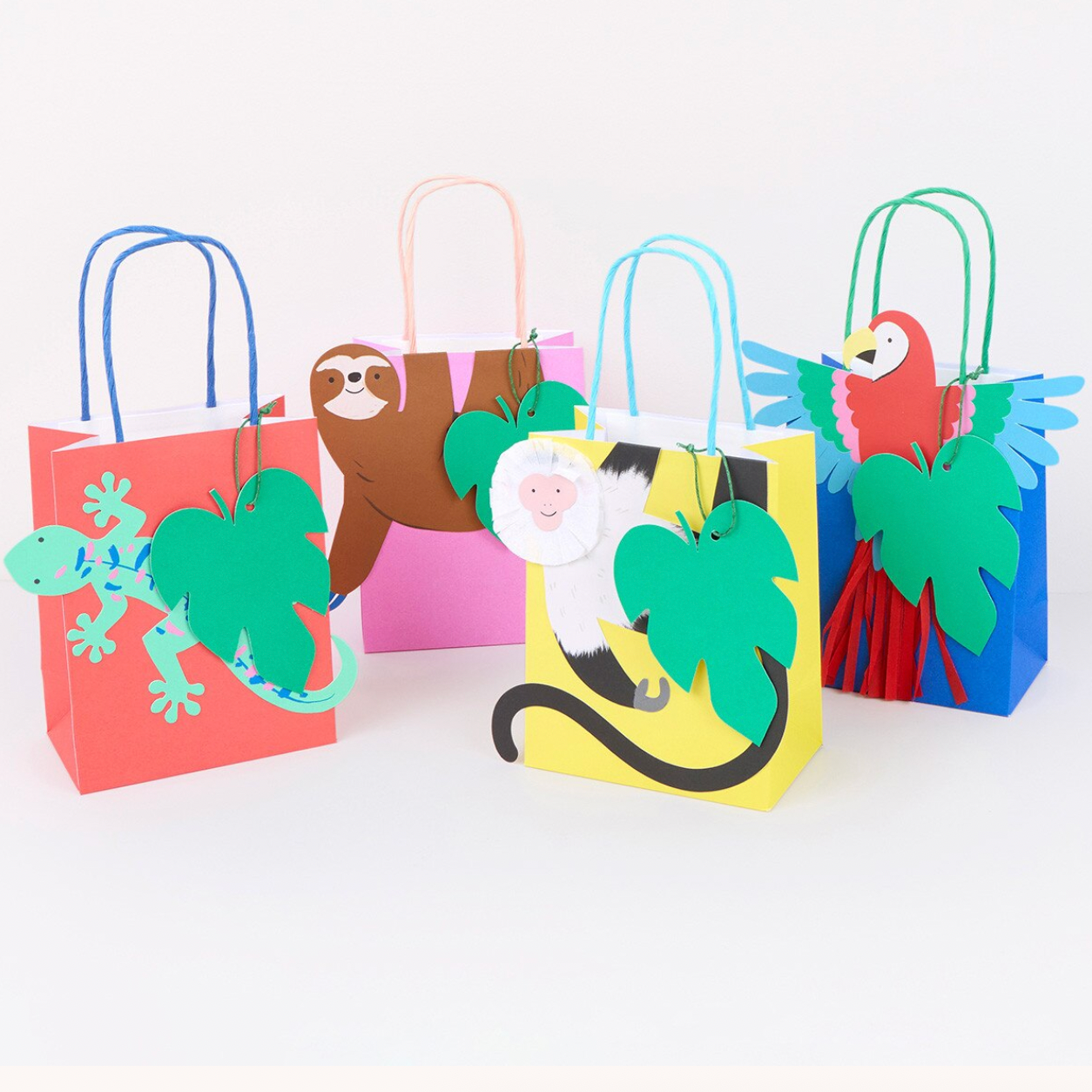 Colorful paper gift bags with animal designs on a white background