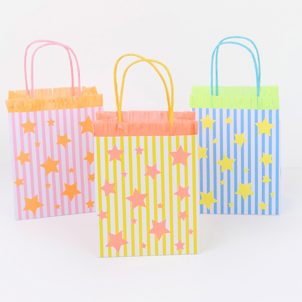 Three colorful paper party bags with star patterns on a white background