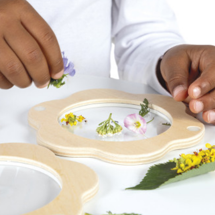 Person arranging flowers on a decorative tray with 'NEW' label