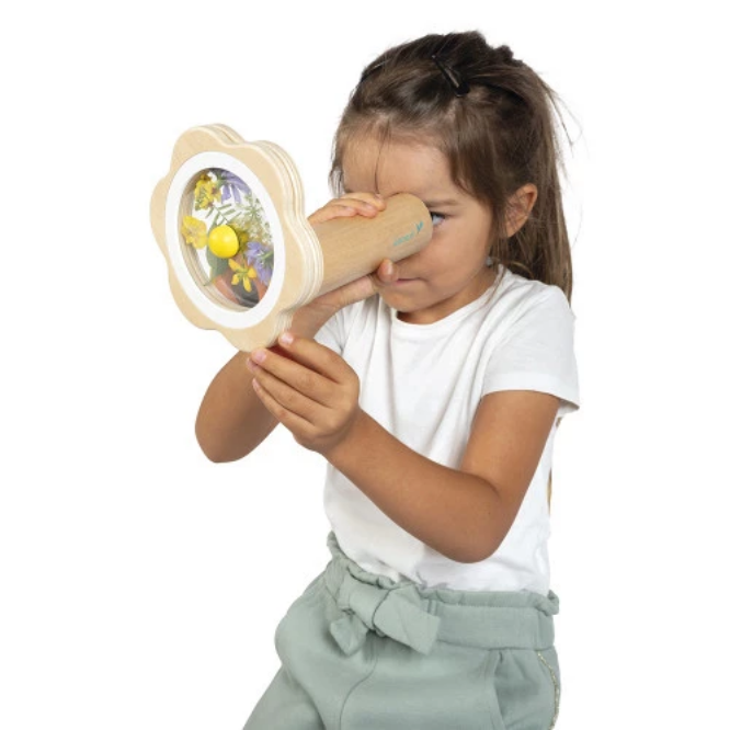 Child playing with a wooden toy that resembles binoculars on a white background