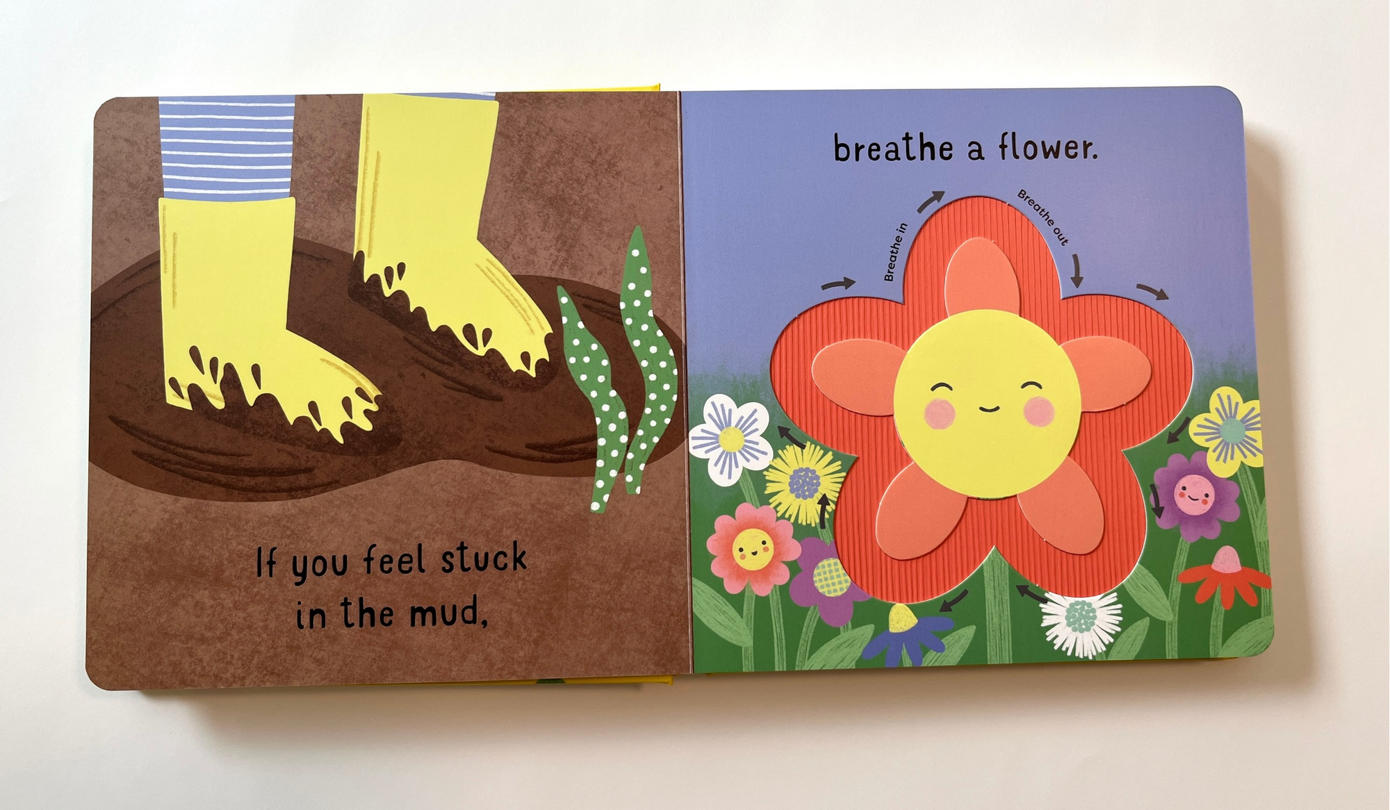 Children's book with illustrations of feet in mud and a smiling flower on a white background