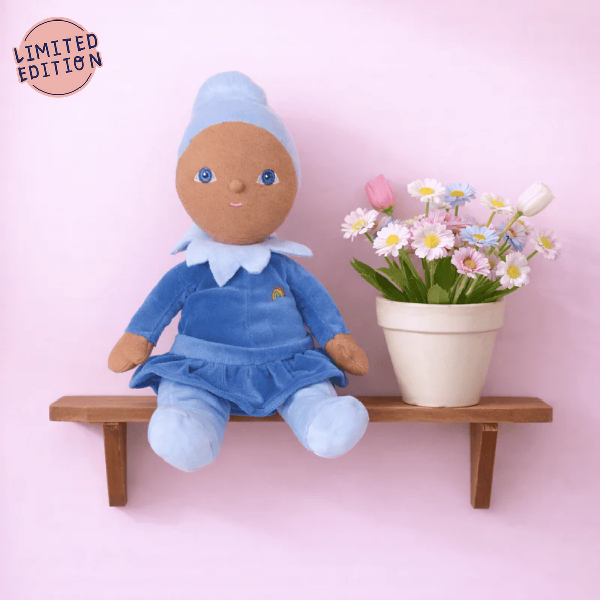 Doll in blue outfit with flowers on pink background
